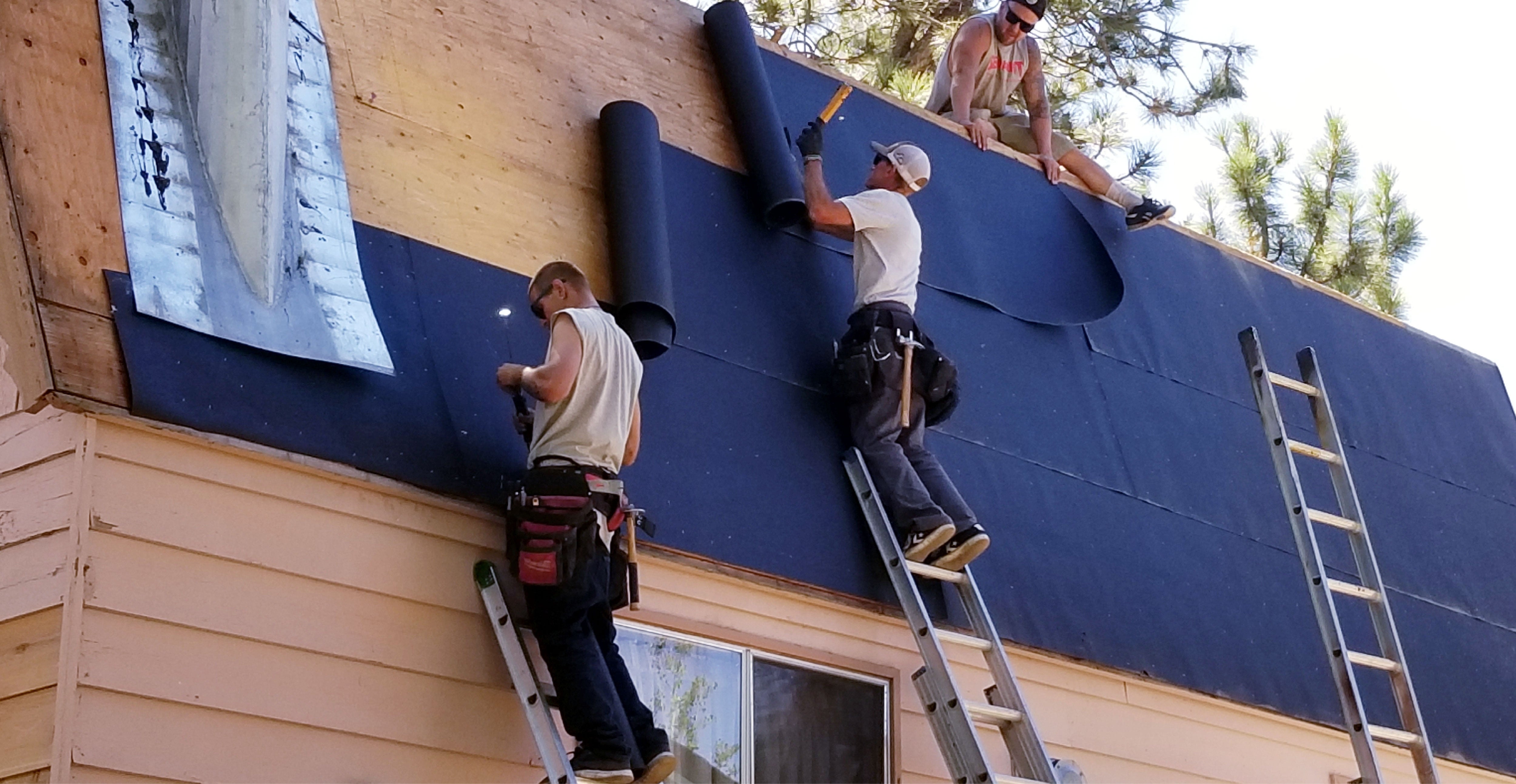 A rooftop in the process of installation, showing layers of roofing membranes being applied.